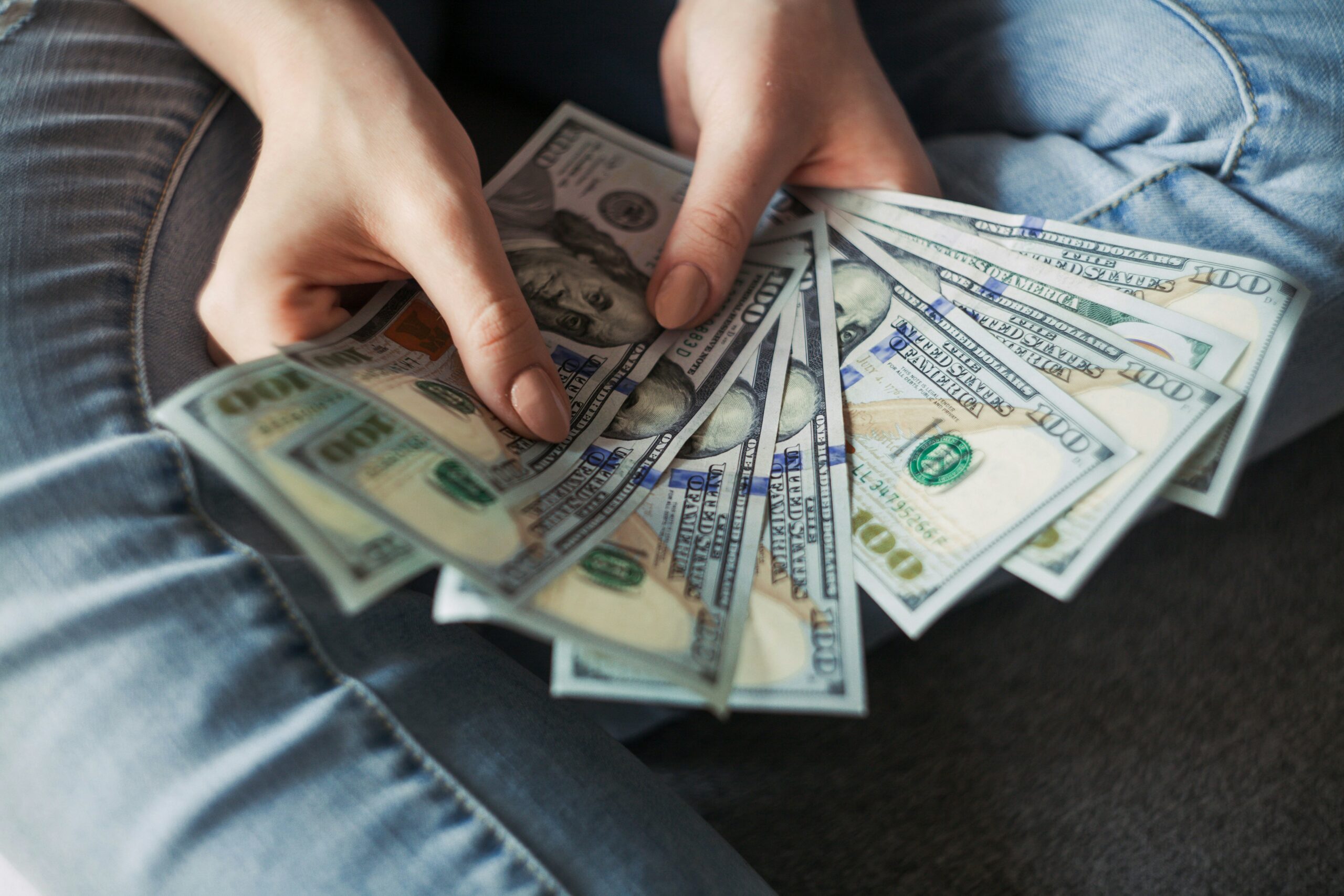 A woman hands holding american dollars.