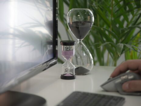 Hourglass in a white business desk.