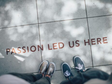 Two people's feet showing a quote on the floor and their shoes.