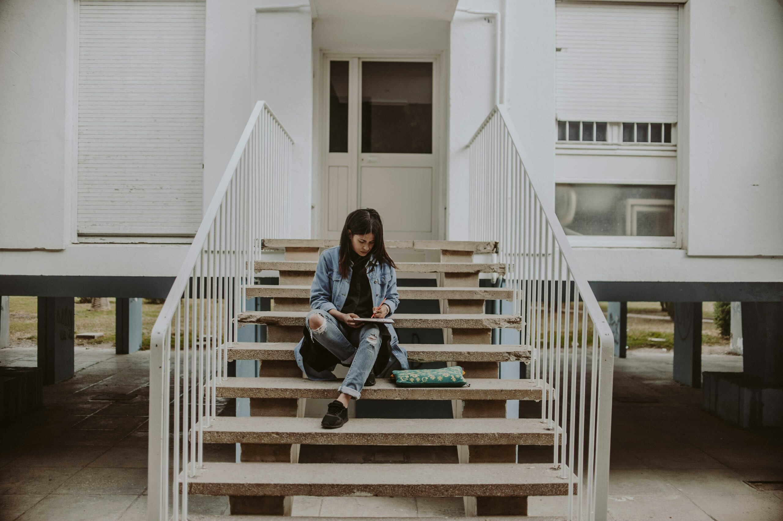 woman sitting on stairs while holding book