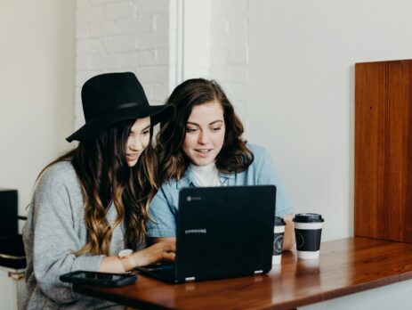 Two women sitting in front of a computer