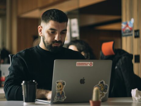 Man in a black shirt using a laptop macbook