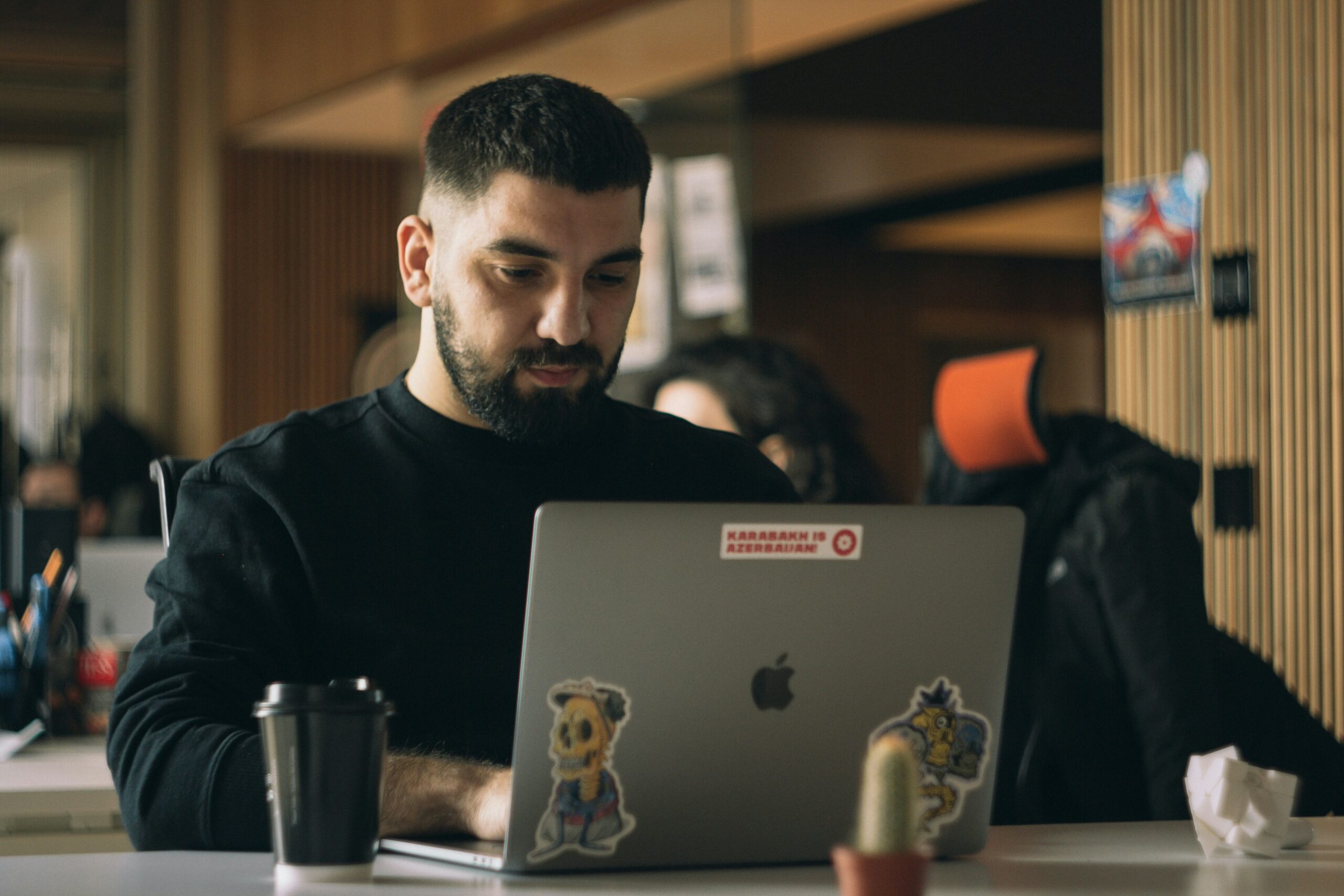 Man in a black shirt using a laptop macbook