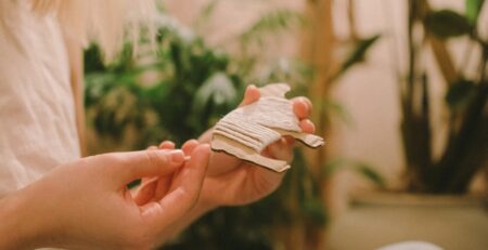 Person holding a white paper airplane