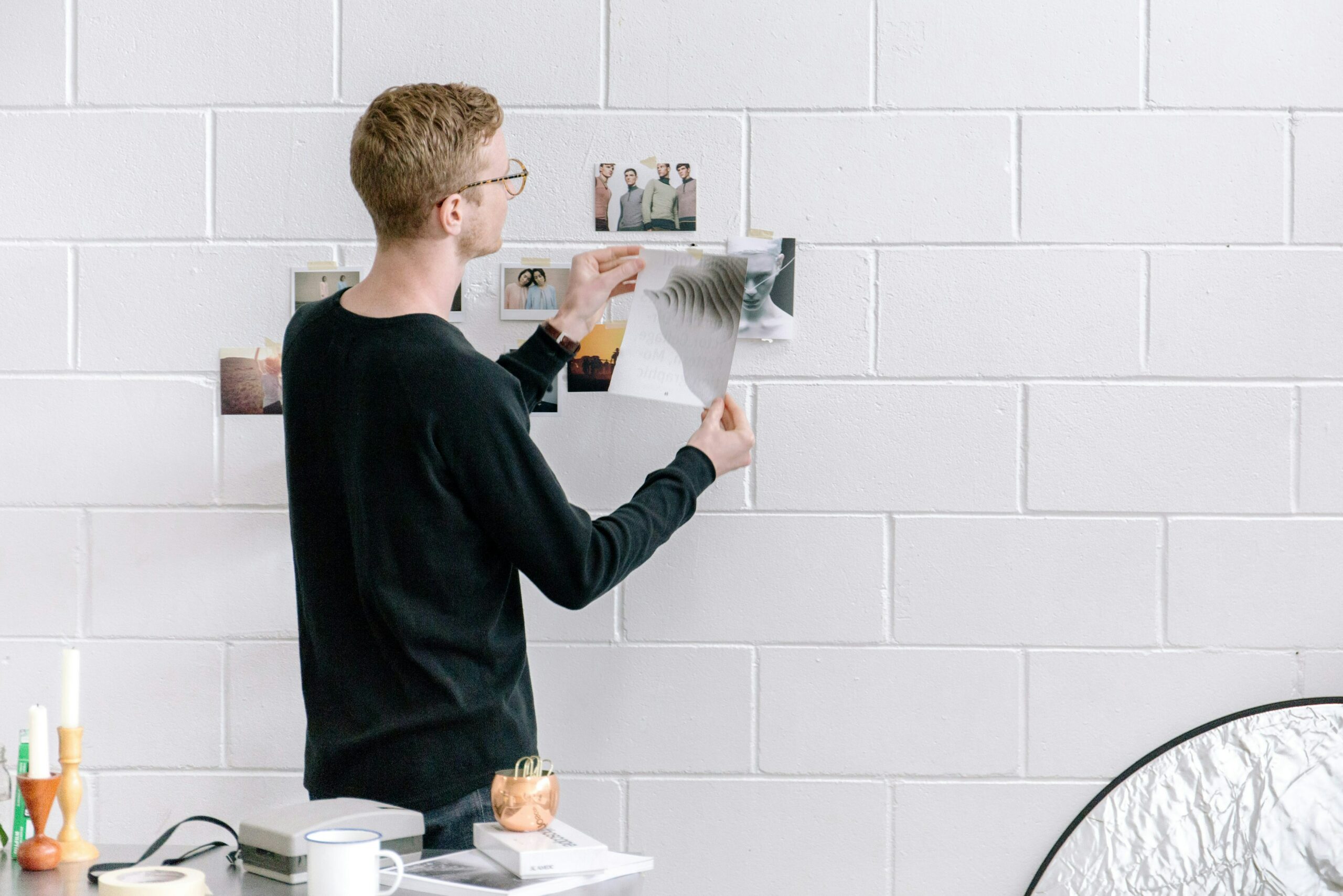 man holding a paper in front of a wall