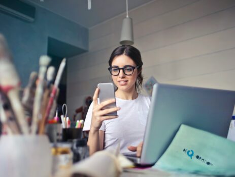 a woman wearing a white shirt using a phone