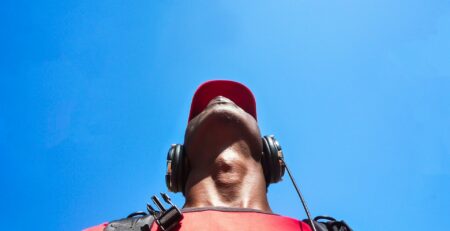 man looking to sky while uses a black headphone