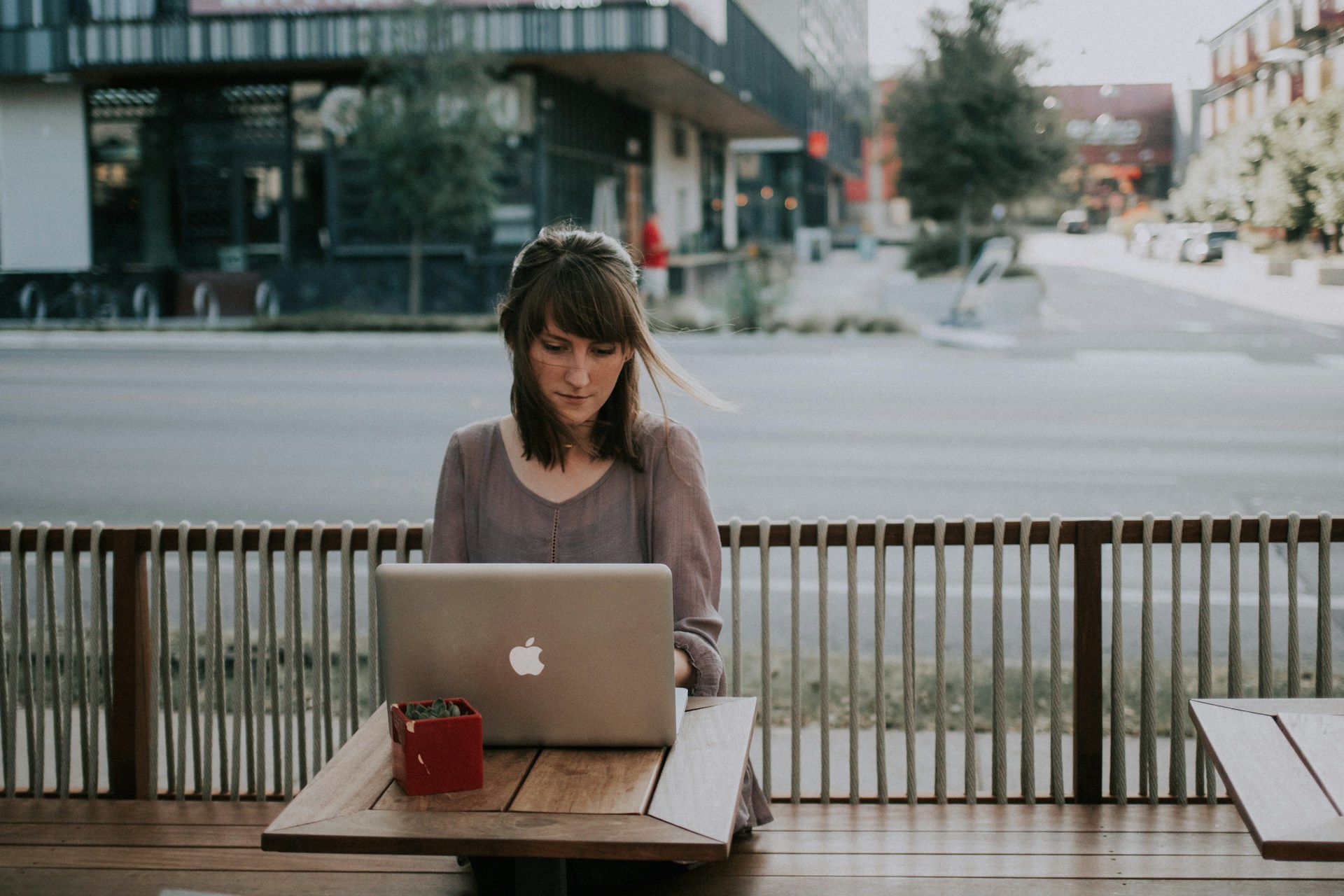 a woman sitting on a bench in front of a macbook