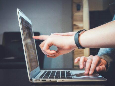 two hands pointing at a laptop