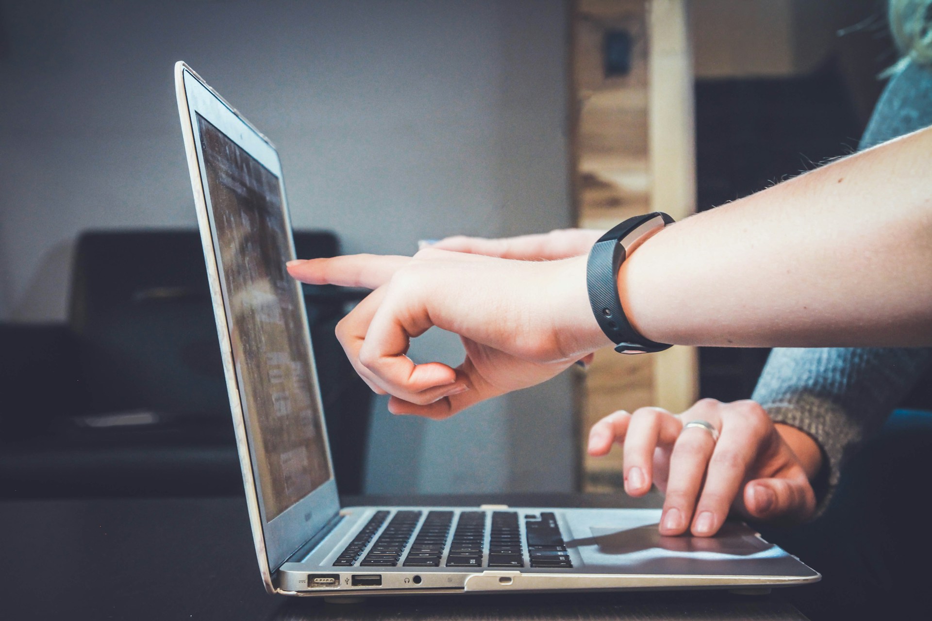 two hands pointing at a laptop