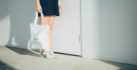 a woman holding a white bag