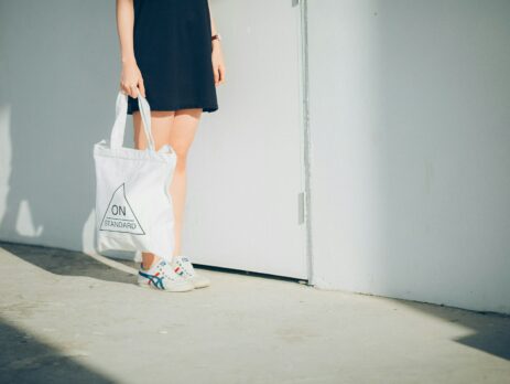 a woman holding a white bag